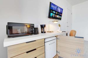 a kitchen with a microwave and a tv on a counter at Amazing Balcony Near Beach in Hallandale Beach +38 photos