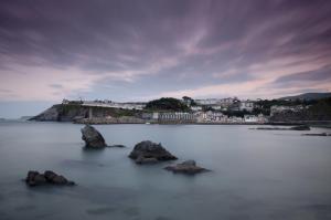 una vista del océano con rocas en el agua en La Casa De Luarca, en Luarca