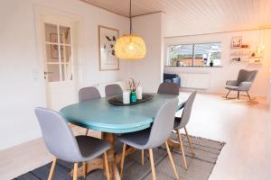 a dining room with a blue table and chairs at Villa Holstebro in Holstebro