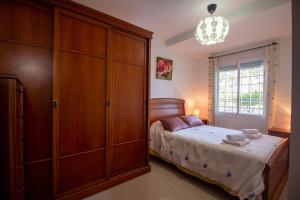 a bedroom with a bed and a large wooden cabinet at SpainKarmaSun in Torrox Costa +59 photos