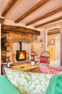 a living room with a fireplace and a couch at Pocket Cottage Luxury 18th Century Tiny Home in Picturesque Village with Pubs in Stillington
