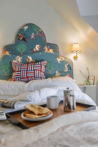 a bed with a table with a plate of food on it at Pocket Cottage Luxury 18th Century Tiny Home in Picturesque Village with Pubs in Stillington