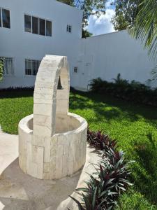 a stone fountain in front of a white building at Casa Victoria Cozumel in Cozumel