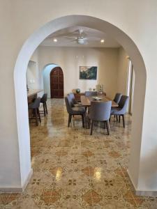 a dining room with an archway and a table and chairs at Casa Victoria Cozumel in Cozumel