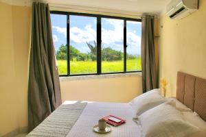 a bedroom with a bed with a view of a window at (108) Beach confort na praia da litorânea in Pimenta +54 photos