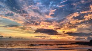a sunset over the ocean with a cloudy sky at Coconut Surf in El Gigante +7 photos