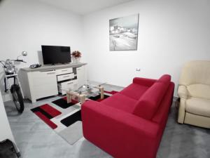 a living room with a red couch and a desk at Mare e Storia da Sabrina in Sassari
