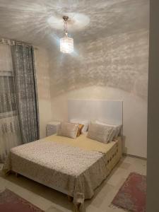 a bedroom with a bed and a chandelier at Résidence les dunes in Hammam Sousse