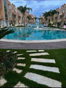 a large swimming pool with blue water in a resort at Résidence les dunes in Hammam Sousse