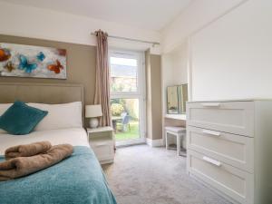 a bedroom with a bed with a dresser and a window at Pound Rocks in Tintagel