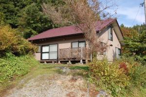 een huis met een terras aan de zijkant bij Chalet 別邸しろうま in Hakuba
