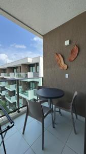 a room with a table and chairs and a balcony at Studio Confortável em Muro Alto in Ipojuca