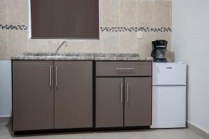 a kitchen with a sink and a refrigerator at Casa Bonita y Amplia in Monclova