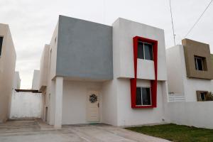 a white building with a red window at Casa Bonita y Amplia in Monclova