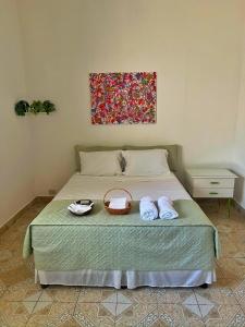 マナグアにあるNica Life Bed & Breakfastのベッドとタオル2枚のある寝室 +2枚の写真
