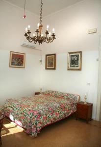 a bedroom with a bed and a chandelier at B&B Villa Pallante in Bari