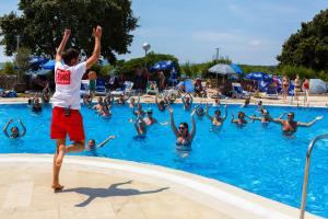 a group of people playing frisbee in a swimming pool at Hotel Dražica - Hotel Resort Dražica in Krk
