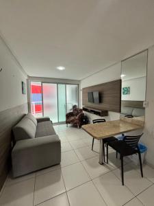 a living room with a couch and a table at Prédio beira mar, apt 211 - praia de Manaíra in João Pessoa