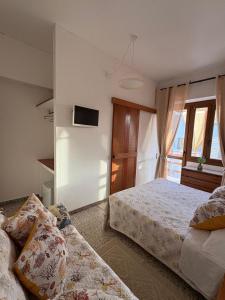 una camera da letto con due letti e una TV a parete di Vittorina's Home a Sorso Altre 37 foto