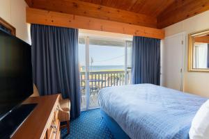 a hotel room with a bed and a balcony at Waves Oceanfront Resort in Old Orchard Beach +48 photos