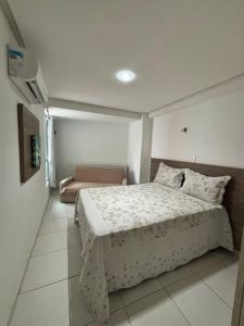 a bedroom with a bed and a couch in it at Prédio beira mar, apt 211 - praia de Manaíra in João Pessoa
