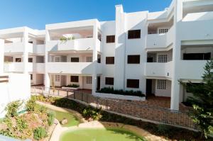 an exterior view of a white building at La Carolina in San Juan de los Terreros
