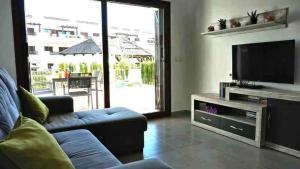 a living room with a couch and a flat screen tv at La Carolina in San Juan de los Terreros
