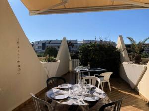 patio ze stołami i krzesłami na balkonie w obiekcie Résidence Héliopolis Bâtiment L - Studio 4 pers CAP d'AGDE MAE-4524 w Cap d'Agde