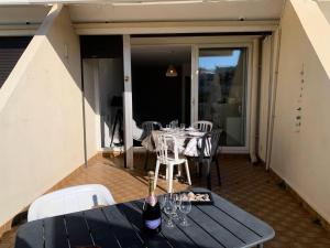 stół z kieliszkami i butelkami wina na patio w obiekcie Résidence Héliopolis Bâtiment L - Studio 4 pers CAP d'AGDE MAE-4524 w Cap d'Agde