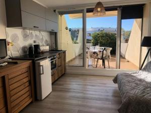 kuchnia z widokiem na patio ze stołem w obiekcie Résidence Héliopolis Bâtiment L - Studio 4 pers CAP d'AGDE MAE-4524 w Cap d'Agde