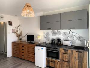 kuchnia z drewnianymi szafkami i białą lodówką w obiekcie Résidence Héliopolis Bâtiment L - Studio 4 pers CAP d'AGDE MAE-4524 w Cap d'Agde