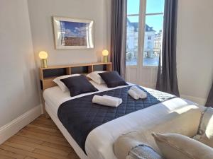 a bedroom with a large bed with two towels on it at La Rotonde - Vue sur Place du Martroi Orléans - Climatisation - 5 pers - Hypercentre in Orléans