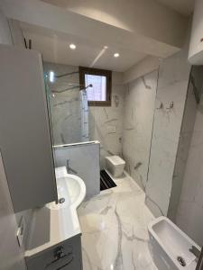 a white bathroom with a sink and a toilet at Casa Ale in Ventimiglia