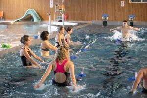 eine Gruppe von Personen im Wasser in einem Schwimmbad in der Unterkunft LA PETITE LUGE studio sur les pistes centre station Super-Besse in Besse-et-Saint-Anastaise