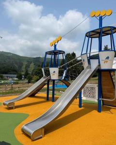 ein Spielplatz mit Rutsche in einem Park in der Unterkunft LA PETITE LUGE studio sur les pistes centre station Super-Besse in Besse-et-Saint-Anastaise