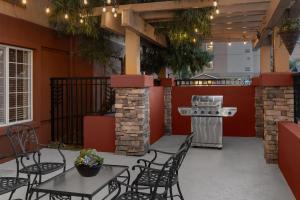 an outdoor patio with tables and chairs and a grill at Larkspur Landing Extended Stay Suites Folsom in Folsom