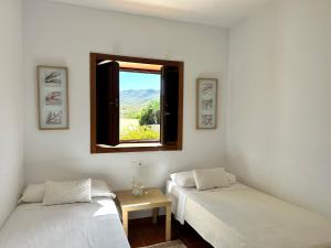 twee bedden in een kamer met een raam bij Villa Filon in Rodalquilar +31 foto's