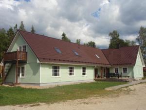 ein grünes Haus mit braunem Dach in der Unterkunft Pauka Holiday House in Palli