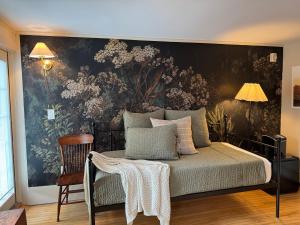 a bedroom with a bed with a floral wall mural at Hideaway Inn Maine in Camden