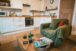 cocina con sofá, mesa y silla en The Prestbury Annexe, en Cheltenham