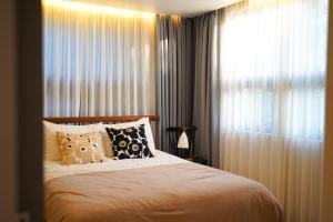 a bedroom with a bed and a window with curtains at Ilo Pension in Seogwipo