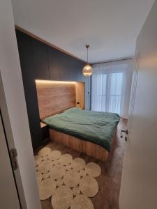 a bedroom with a green bed and a window at M&E Prishtina apartment in Prishtinë