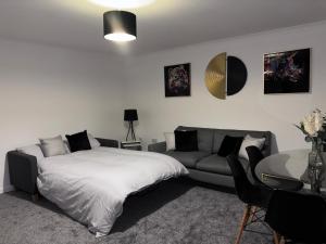 a bedroom with a bed and a couch and a table at Modern 3 bedroom detached house in Sutton Bridge
