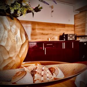 a plate of food on a table next to a vase at Lira Beach Studio in Mamaia