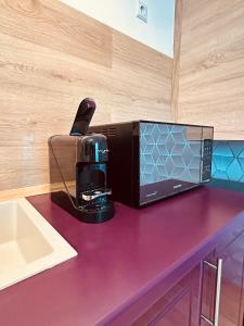 a microwave sitting on top of a purple counter at Lira Beach Studio in Mamaia