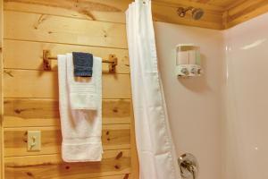 une salle de bain avec une douche avec un rideau de douche blanc dans l'établissement Hendersonville Cabin Near Hiking and Waterfalls!, à Hendersonville 20 autres photos