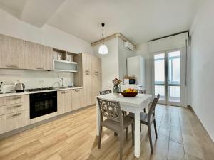- une cuisine avec une table et des chaises blanches dans la chambre dans l'établissement La Residenza, appartamento centrale e moderno - Marea Stays Collection, à Nardò