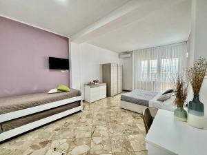 - une chambre avec 2 lits, une table et une télévision dans l'établissement La Residenza, appartamento centrale e moderno - Marea Stays Collection, à Nardò