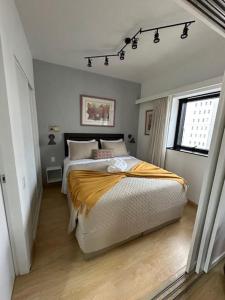 圣保罗Flat Aconchegante nos Jardins的一间卧室，里面有一张床和一扇窗户。