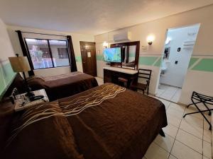 a hotel room with two beds and a television at Motel Jabaloyas in Tijuana